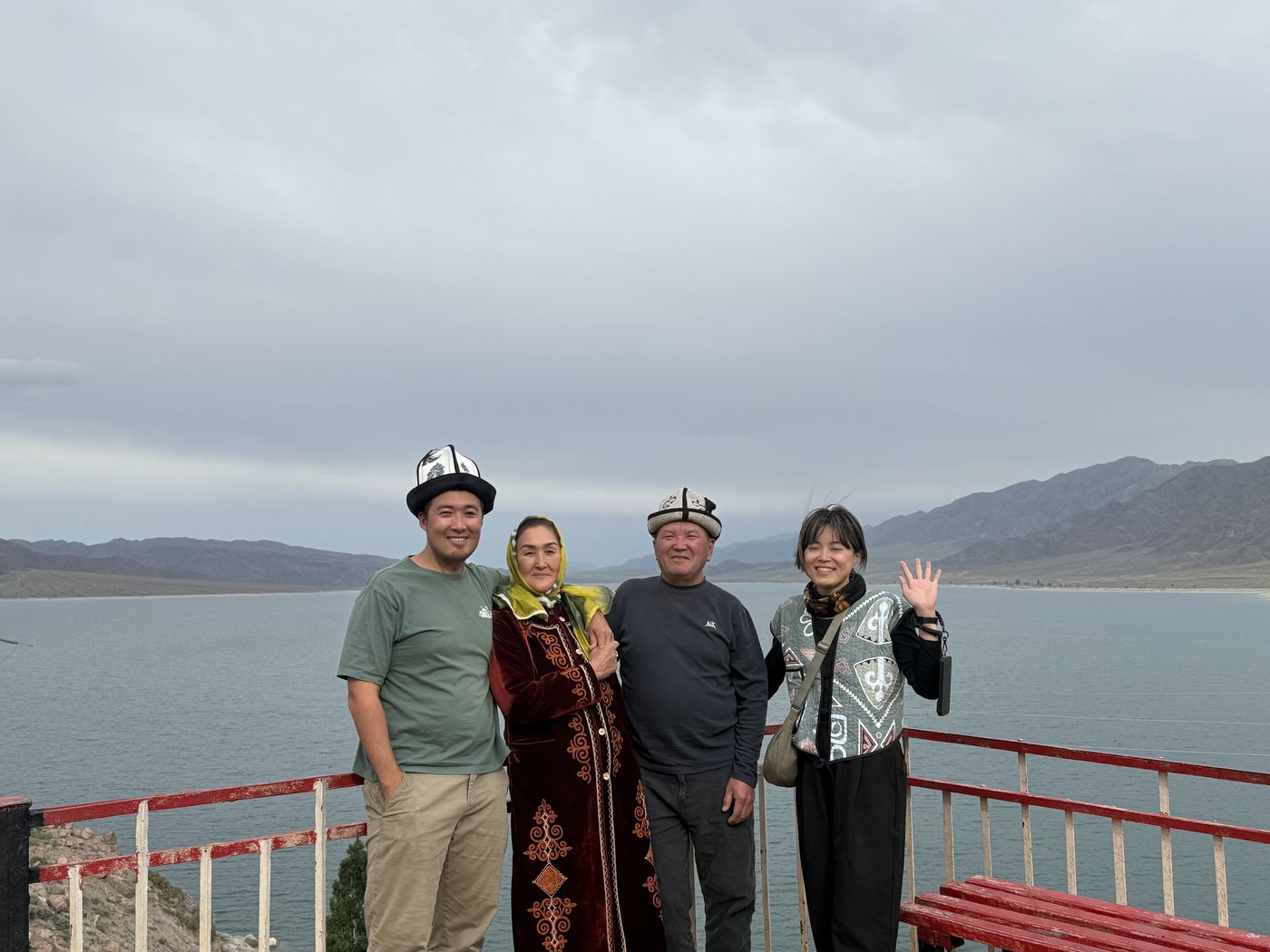 Guests with hosts in traditional dress by the lake