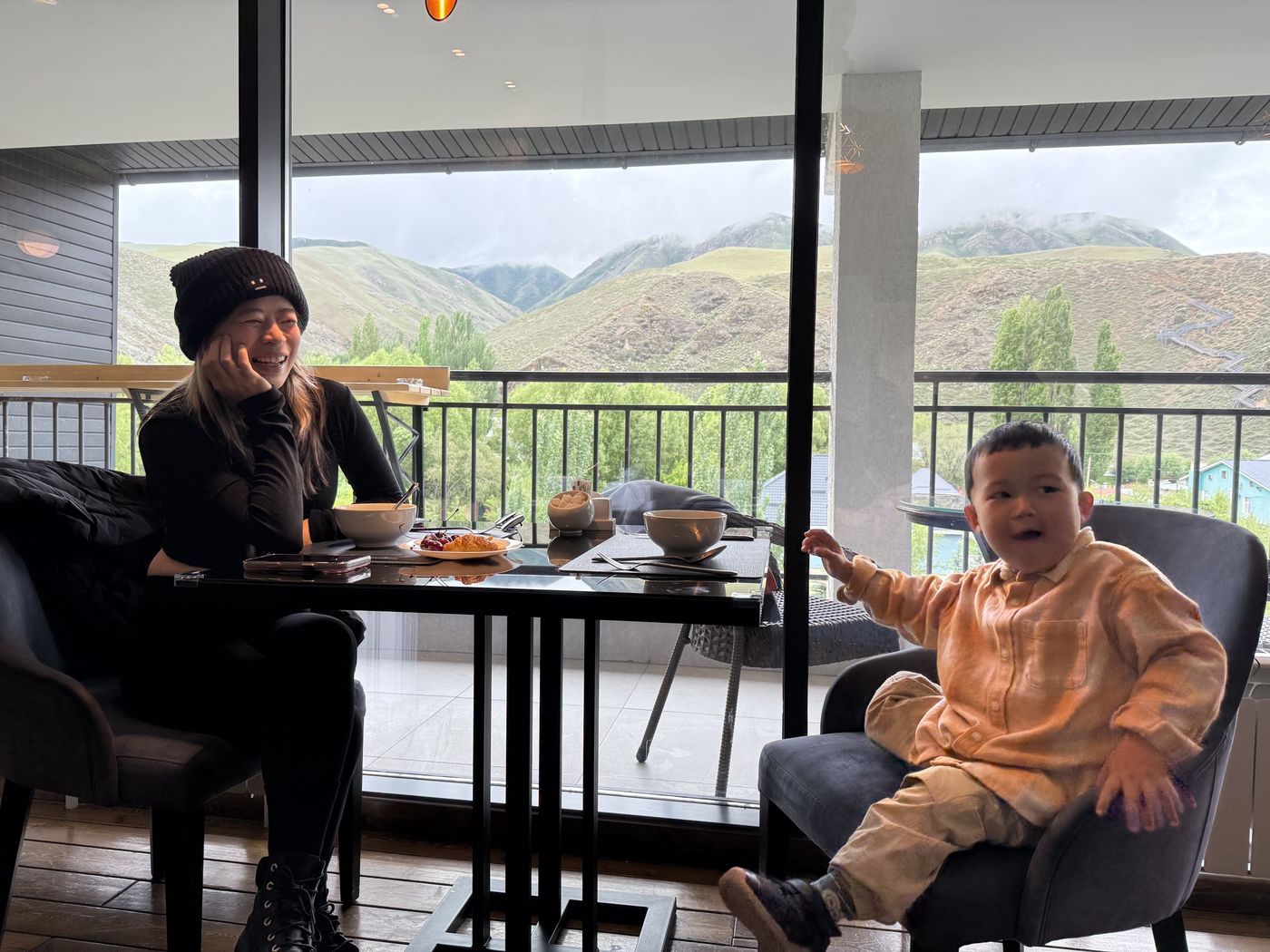 A guest and a child at a café with mountain views