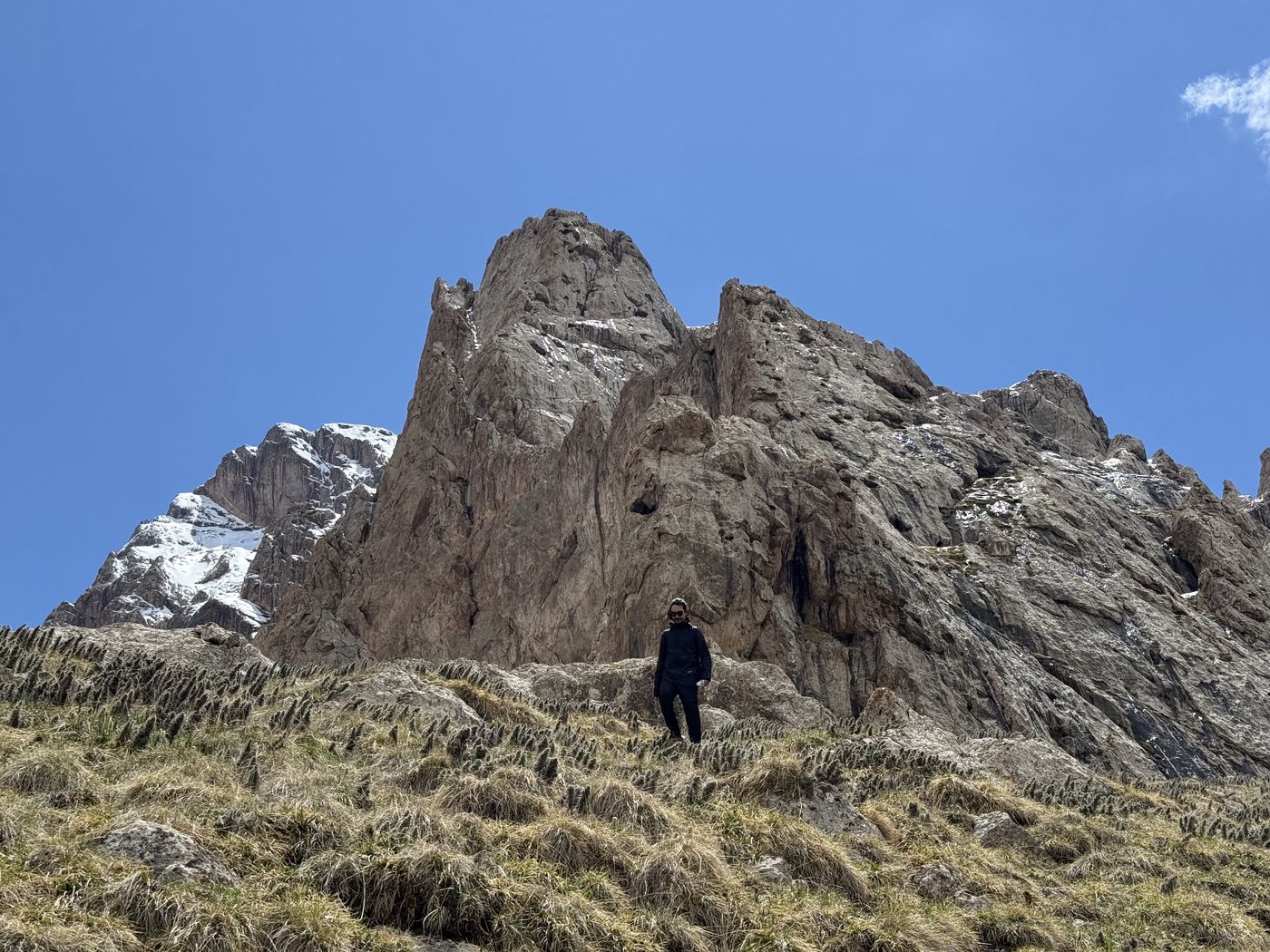 A hiker below a rocky peak