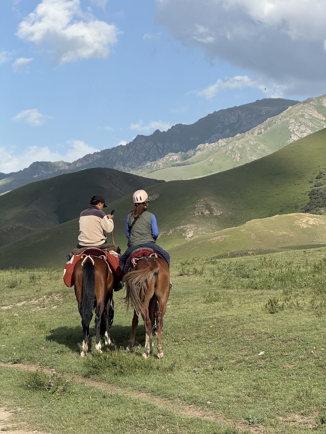 Two riders on a green mountain trail