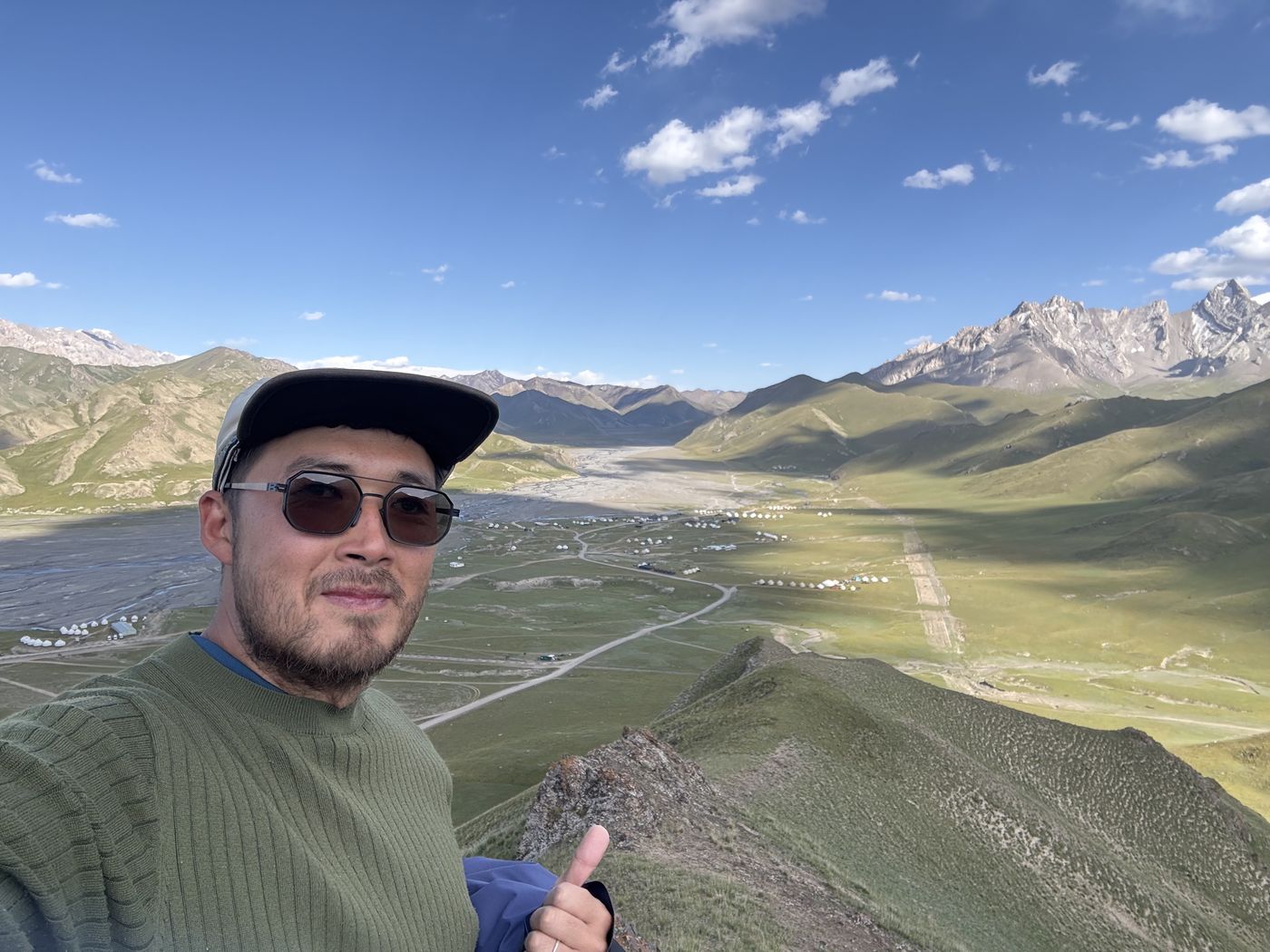 A selfie above a wide mountain valley