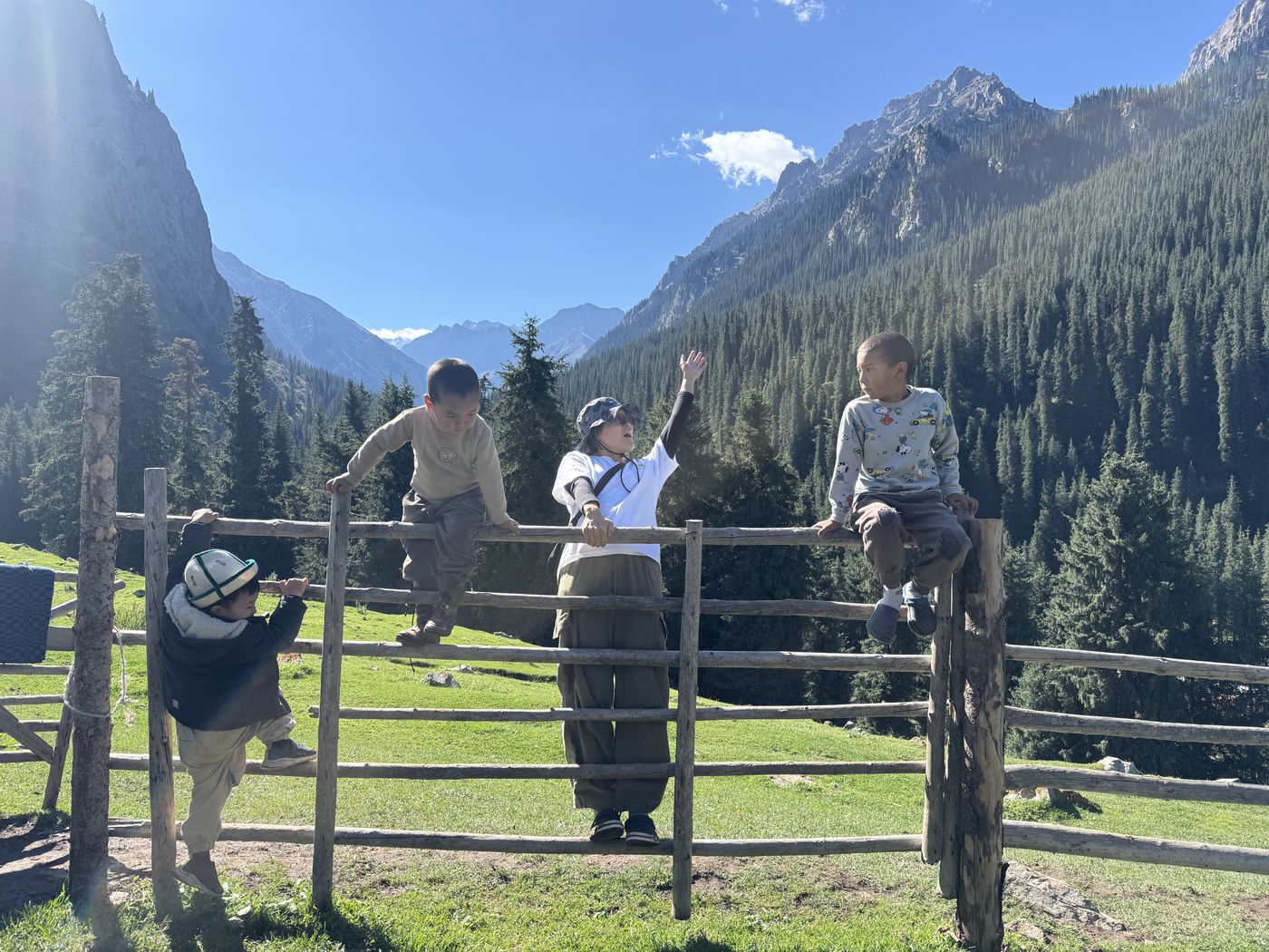 Children on a fence in a mountain valley